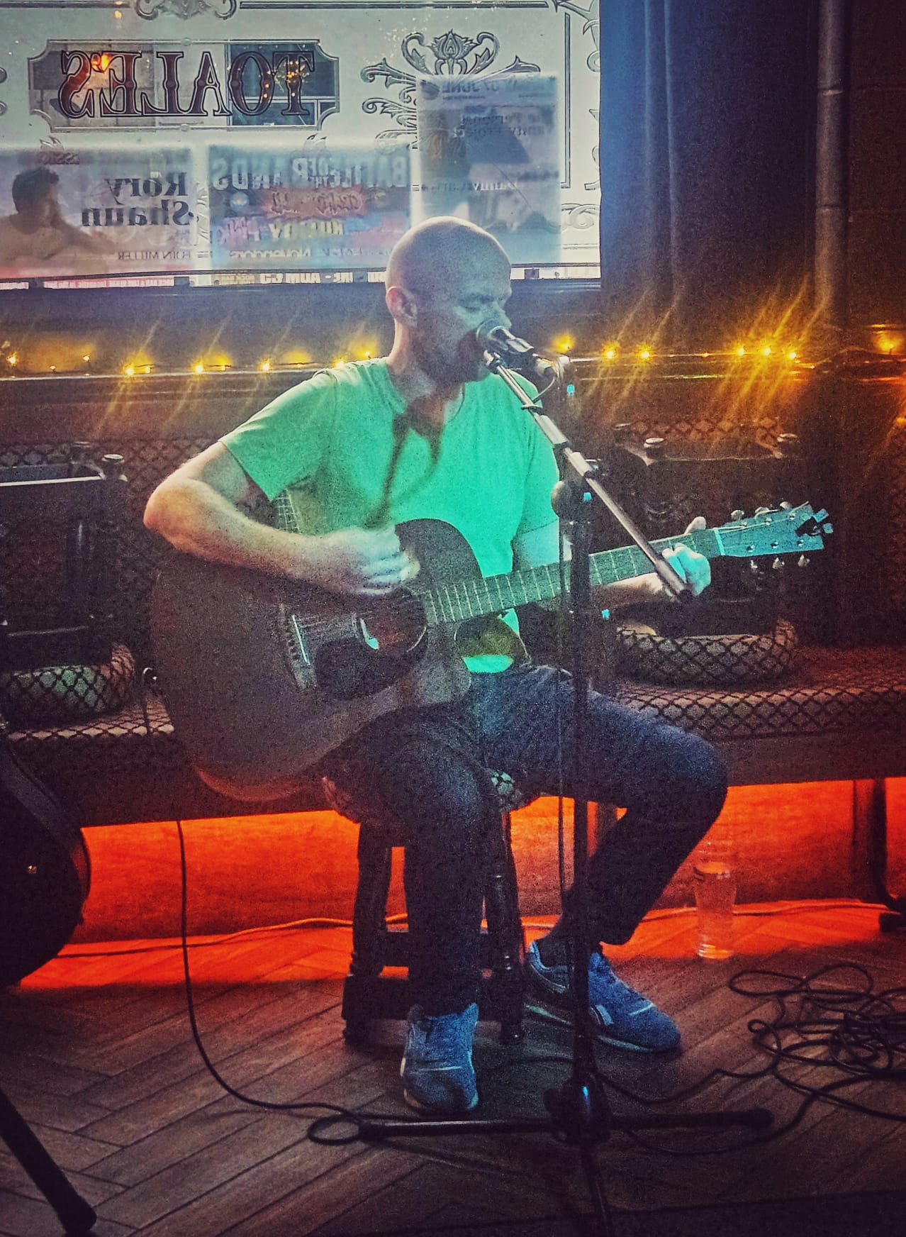 colour picture of eoin with guitar in a pub